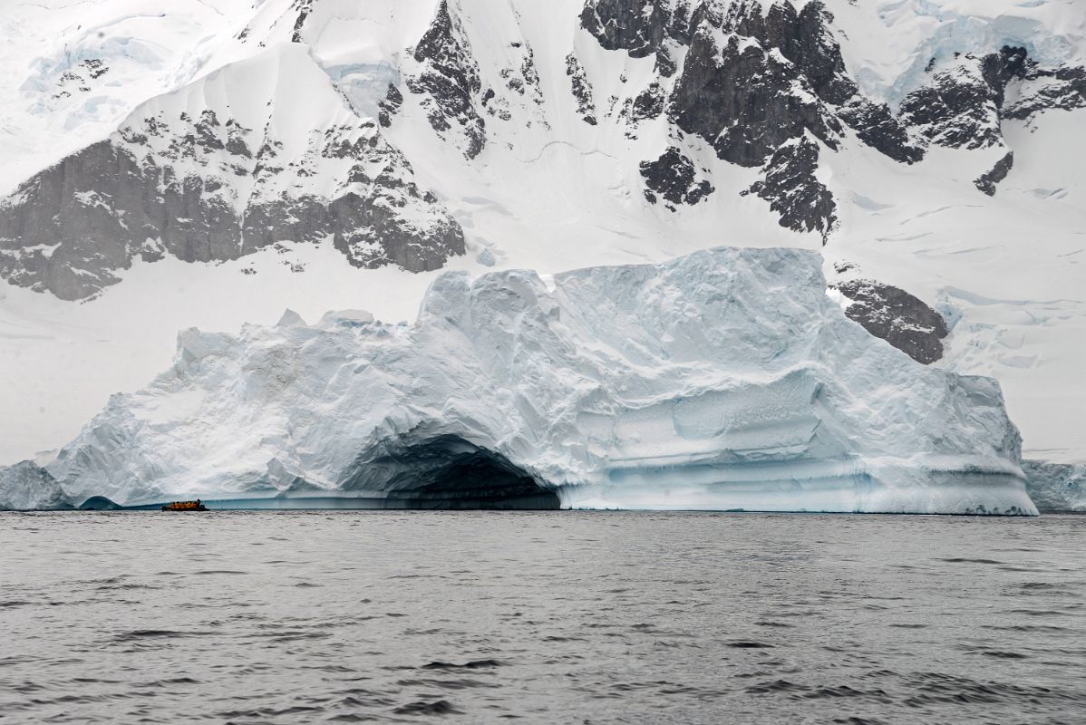 03A Zodiac Dwarfed By A Huge Iceberg With A Small Cave Near Danco Island On Quark Expeditions Antarctica Cruise